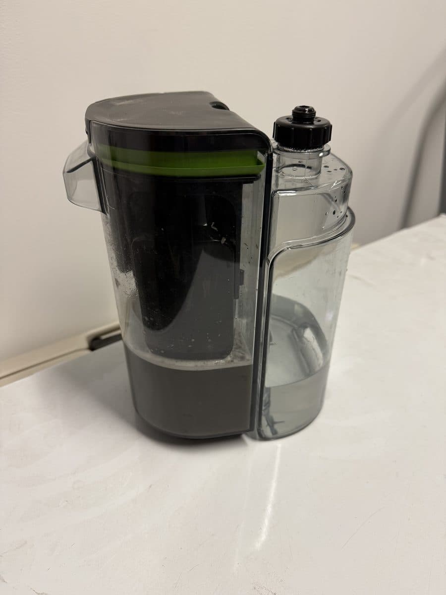 Dirty extraction water next to clean water after an interior detail